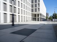 a concrete slab laying in the middle of a sidewalk surrounded by buildings and trees with the light on at the end of the street