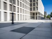 a concrete slab laying in the middle of a sidewalk surrounded by buildings and trees with the light on at the end of the street