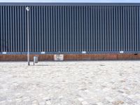 a brick building with glass windows and sidewalk leading to it and a black fire hydrant