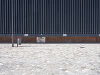 a brick building with glass windows and sidewalk leading to it and a black fire hydrant