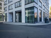 the large building with many glass doors is very modern looking in the city setting of the city