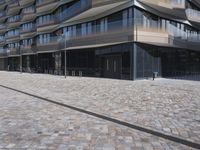 a brick building with glass windows and sidewalk leading to it and a black fire hydrant