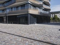 a brick building with glass windows and sidewalk leading to it and a black fire hydrant