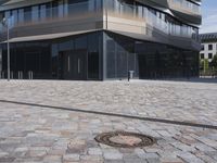 a brick building with glass windows and sidewalk leading to it and a black fire hydrant