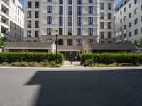 an apartment building on the corner of a street and two other buildings around it are empty