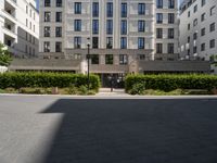 an apartment building on the corner of a street and two other buildings around it are empty