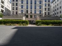 an apartment building on the corner of a street and two other buildings around it are empty