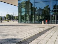 a man with a suitcase is looking at an empty walkway next to some glass buildings