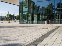 a man with a suitcase is looking at an empty walkway next to some glass buildings