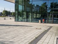 a man with a suitcase is looking at an empty walkway next to some glass buildings