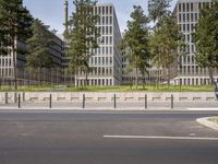 a very tall building next to a road with trees in the front of it that is made of stone