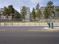 a very tall building next to a road with trees in the front of it that is made of stone