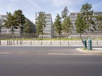 a very tall building next to a road with trees in the front of it that is made of stone