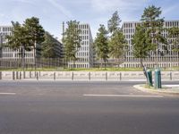 a very tall building next to a road with trees in the front of it that is made of stone