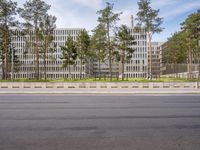 a very tall building next to a road with trees in the front of it that is made of stone