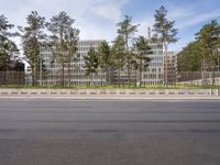 a very tall building next to a road with trees in the front of it that is made of stone