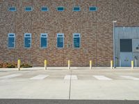 a brick building with multiple windows and columns on it's side, in front of a crosswalk