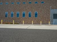 a brick building with multiple windows and columns on it's side, in front of a crosswalk