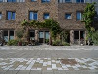 large brick building with patio and lawn in front of it's door way and window