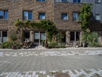 large brick building with patio and lawn in front of it's door way and window