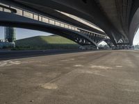 the road is empty with many cars parked on it near an overpass and a highway bridge