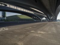 the road is empty with many cars parked on it near an overpass and a highway bridge