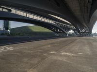 the road is empty with many cars parked on it near an overpass and a highway bridge