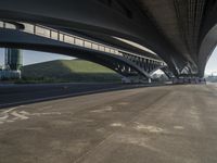 the road is empty with many cars parked on it near an overpass and a highway bridge