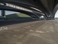 the road is empty with many cars parked on it near an overpass and a highway bridge