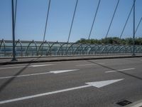 a truck driving across a bridge near a street corner near buildings and a bridge with many cables