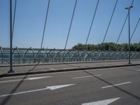 a truck driving across a bridge near a street corner near buildings and a bridge with many cables