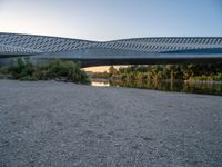 there are two very long bridges that are above the river shore at dusk here, and you can see how close them are