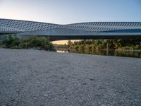 there are two very long bridges that are above the river shore at dusk here, and you can see how close them are