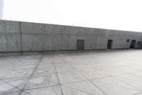 a large gray building with some concrete walls and a closed door in it's center