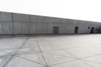 a large gray building with some concrete walls and a closed door in it's center