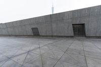 a large gray building with some concrete walls and a closed door in it's center