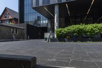 a concrete street with trees growing in front of it and building on the corner of the street