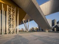 modern building architecture with a blue sky and a few buildings in the background under a bridge