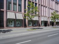 a building with awnings and some trees in front of it and a street