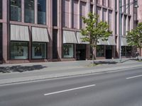 a building with awnings and some trees in front of it and a street