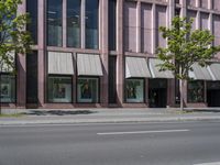 a building with awnings and some trees in front of it and a street