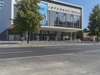 a modern building with many trees growing out the side and in front of it,