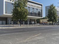 a modern building with many trees growing out the side and in front of it,