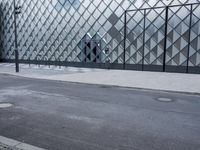 people are walking on a sidewalk near the modern building in paris, france - architecture made from metal and stone