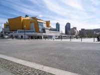 a large yellow building in a city near a body of water with tall buildings on either side