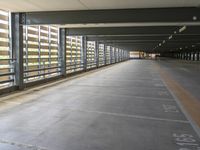 the inside walkway of an empty building with the doors open and the parking spaces empty