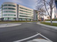 a modern looking building with an empty street in front of it with an arrow pointing