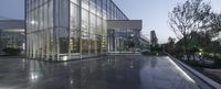 glass windows in a modern building in the evening time lit by a street lamp at dusk