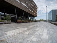 the empty walkway leads to a modern building in this city area of a large, narrow, stone area