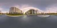 a 360 - view photo of a street and a large modern building on either side of the road